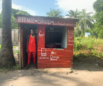 A foto mostra Jeremie na porta de sua loja vermelha