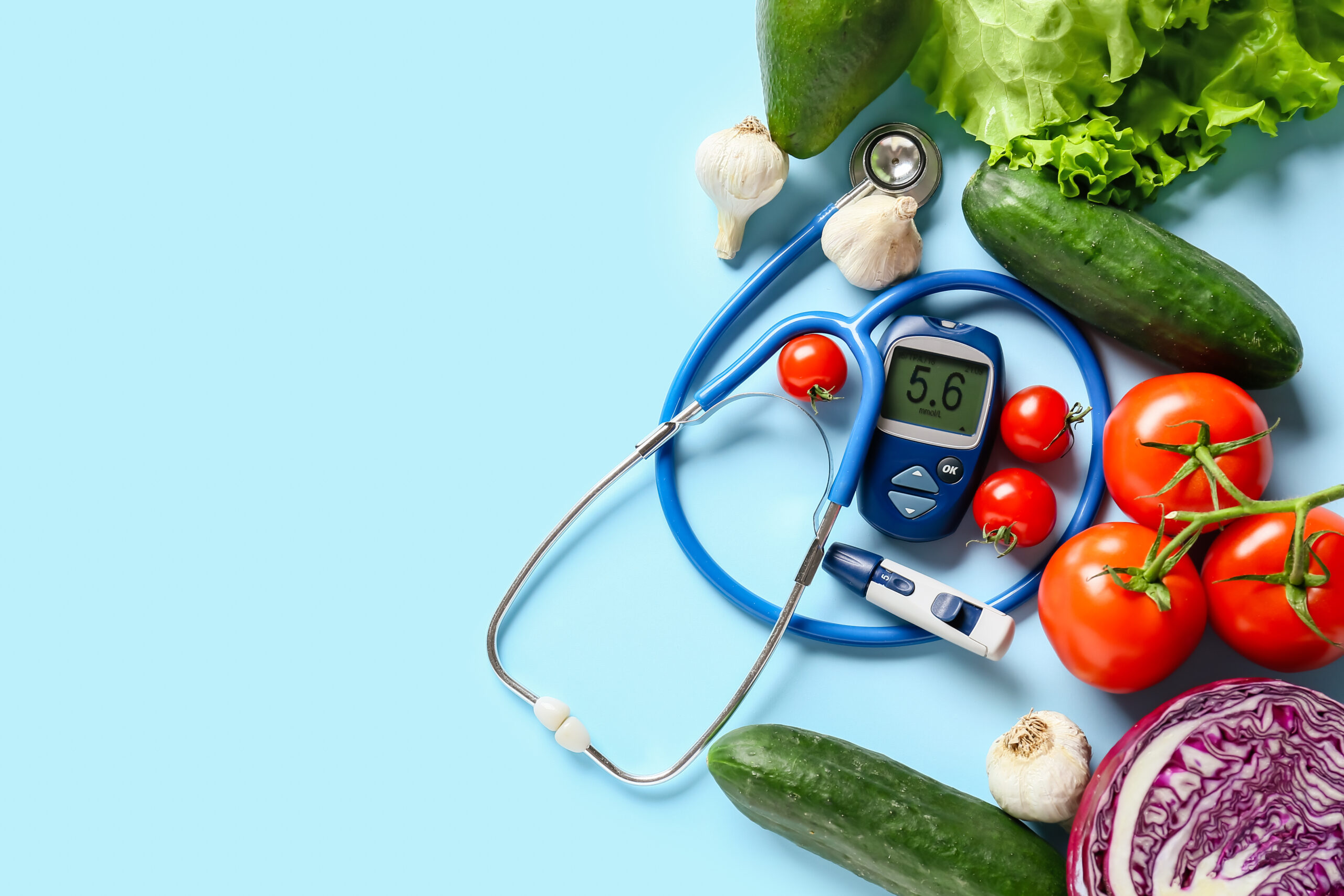 Vegetables, stethoscope, lancet pen and glucometer on color back