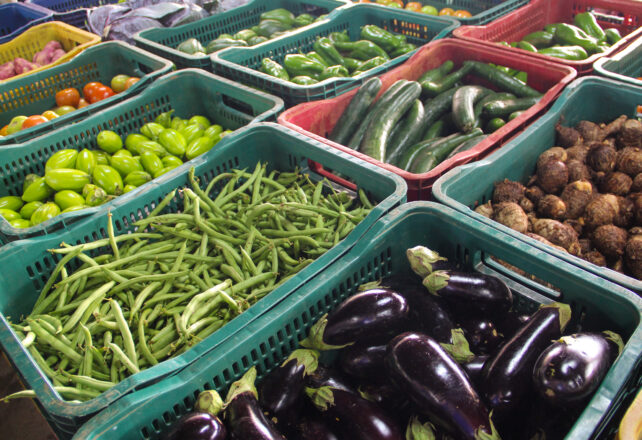 Frutas e legumes em caixotes de plástico verdes