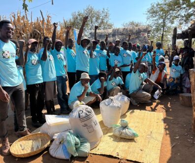 Diversos agricultores negros comemorando o fim das capacitações do projeto Além do Algodão. Todos usam uma camisa azul com a logo do projeto