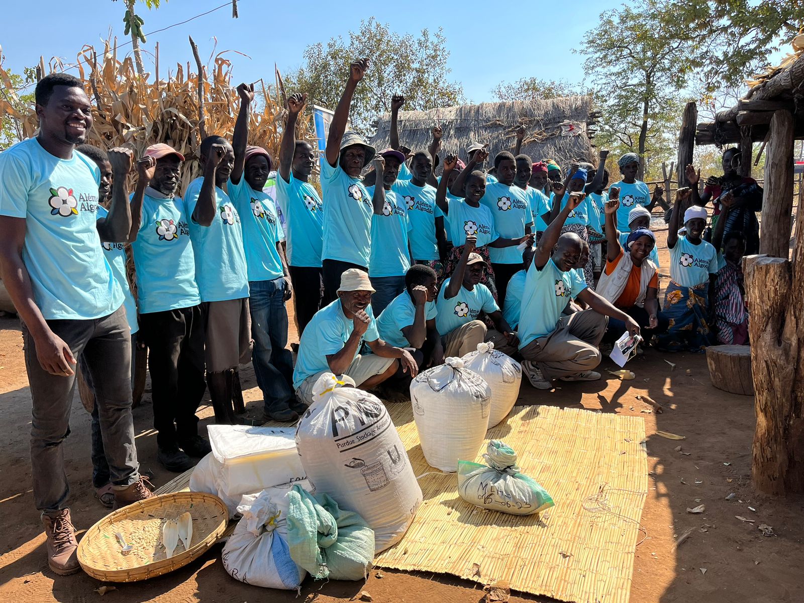 Diversos agricultores negros comemorando o fim das capacitações do projeto Além do Algodão. Todos usam uma camisa azul com a logo do projeto