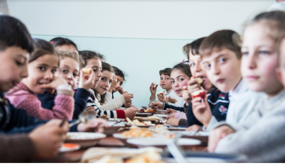 The photo shows Armenian children eating during break time at school.